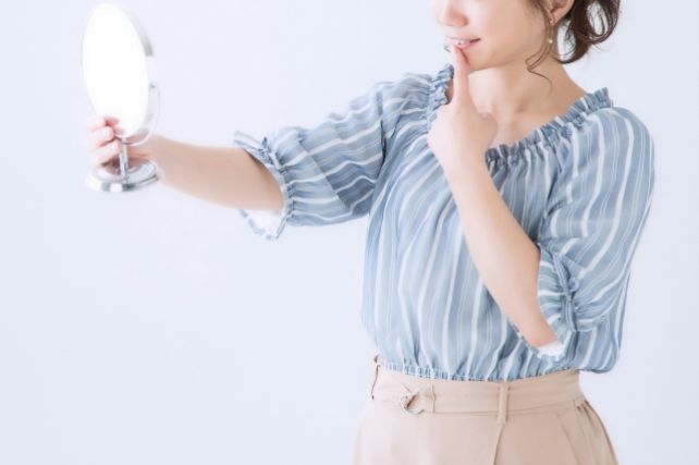 woman-look-teeth-mirror